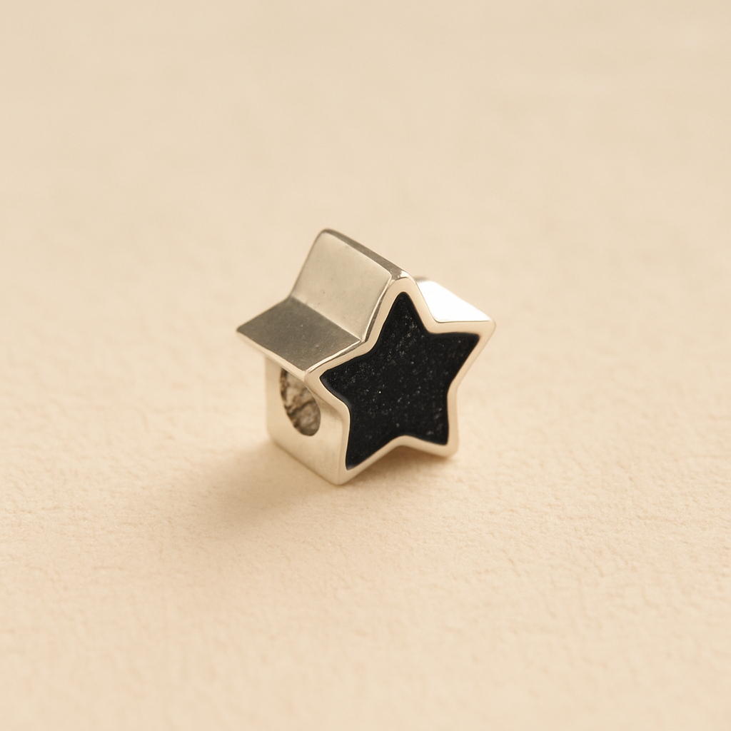 Silver star-shaped Memorial Charm Bead with black resin on a beige background