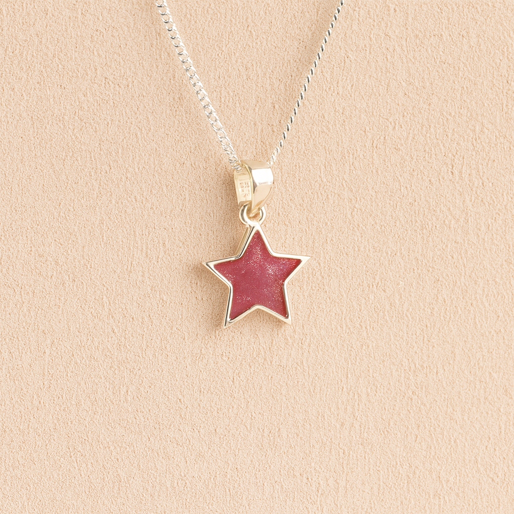 Silver star ashes necklace with dark pink resin on a beige background