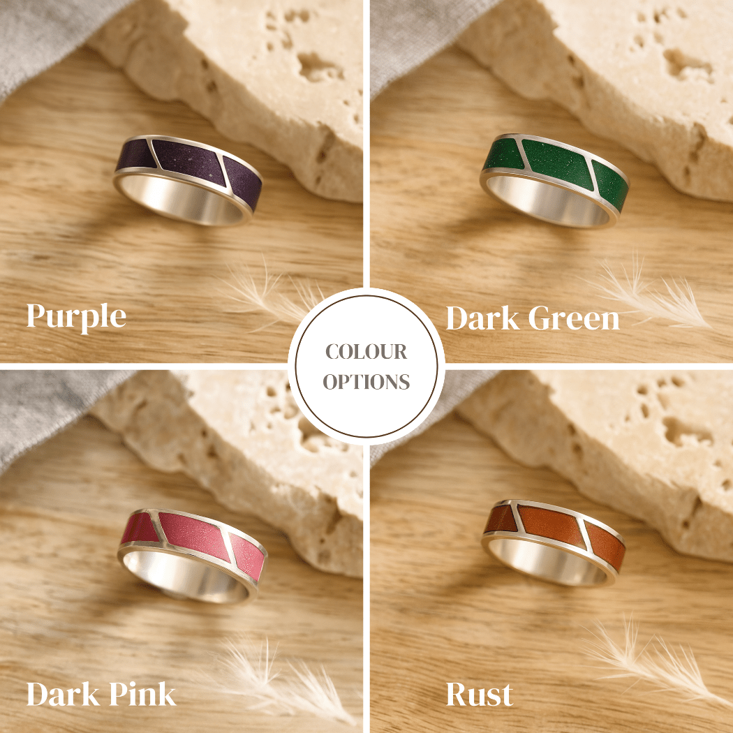 Four ashes rings for men in different colors displayed on a wooden surface with text indicating color options.