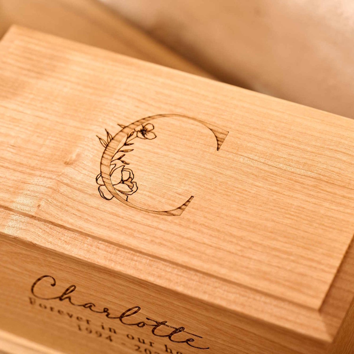 Detailed view of custom floral engraving on wooden urn.