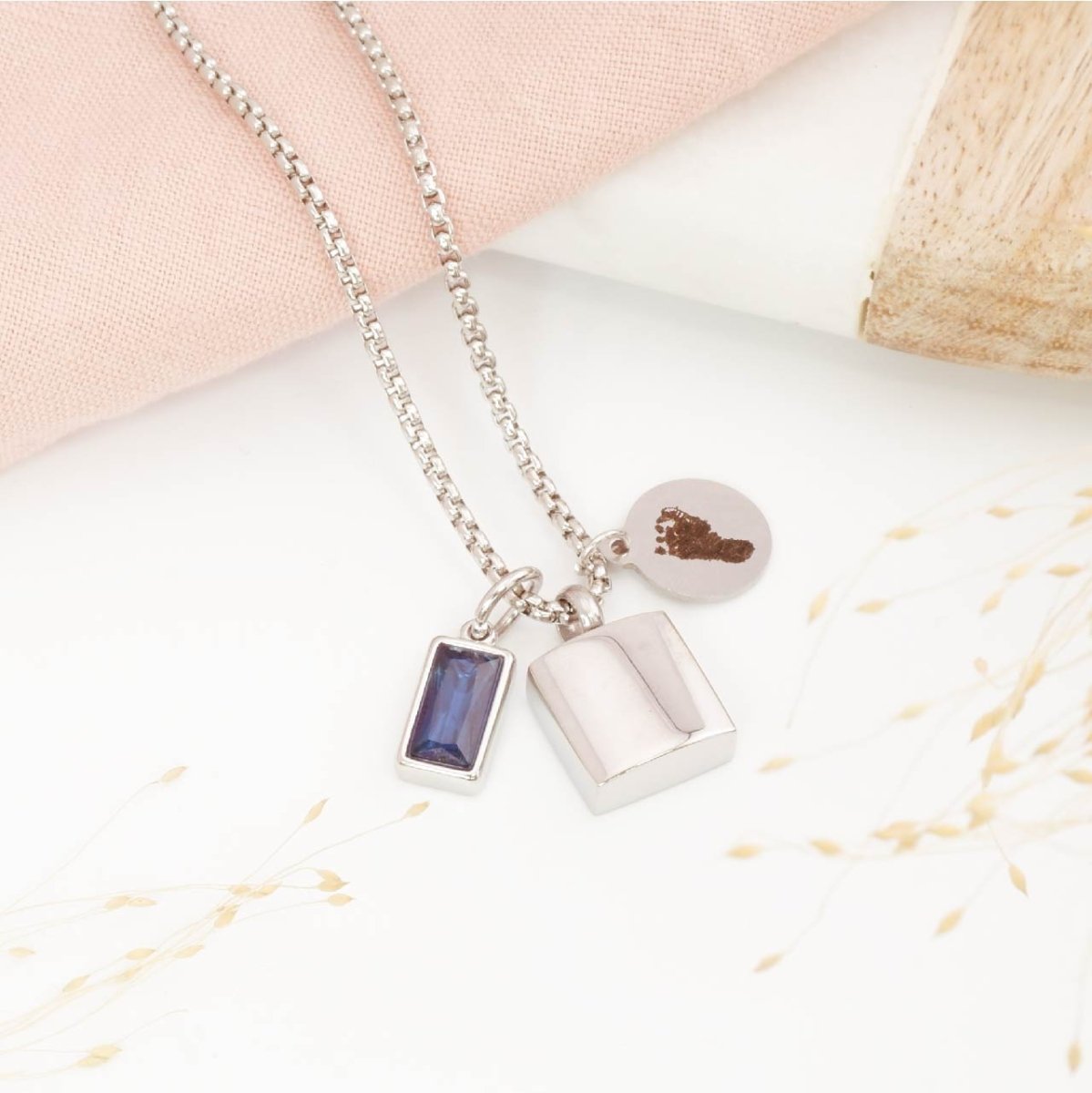 Footprint Necklace for men with urn pendant and birthstone charm on a light background