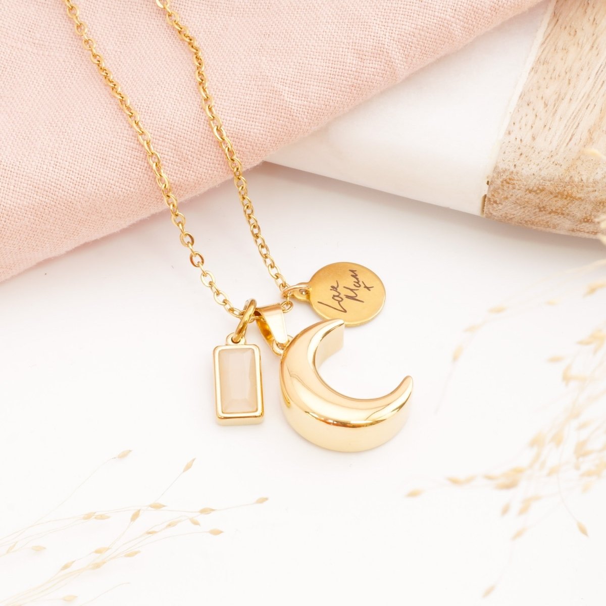 Gold self fill handwriting ashes necklace on a table