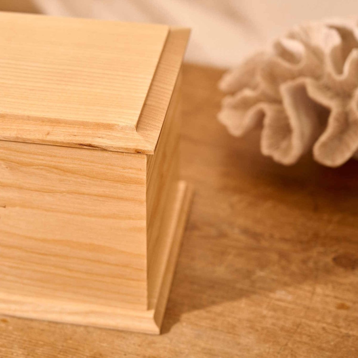 Close-up of engraved ash wood cremation urn for human ashes – detailed view of custom memorial