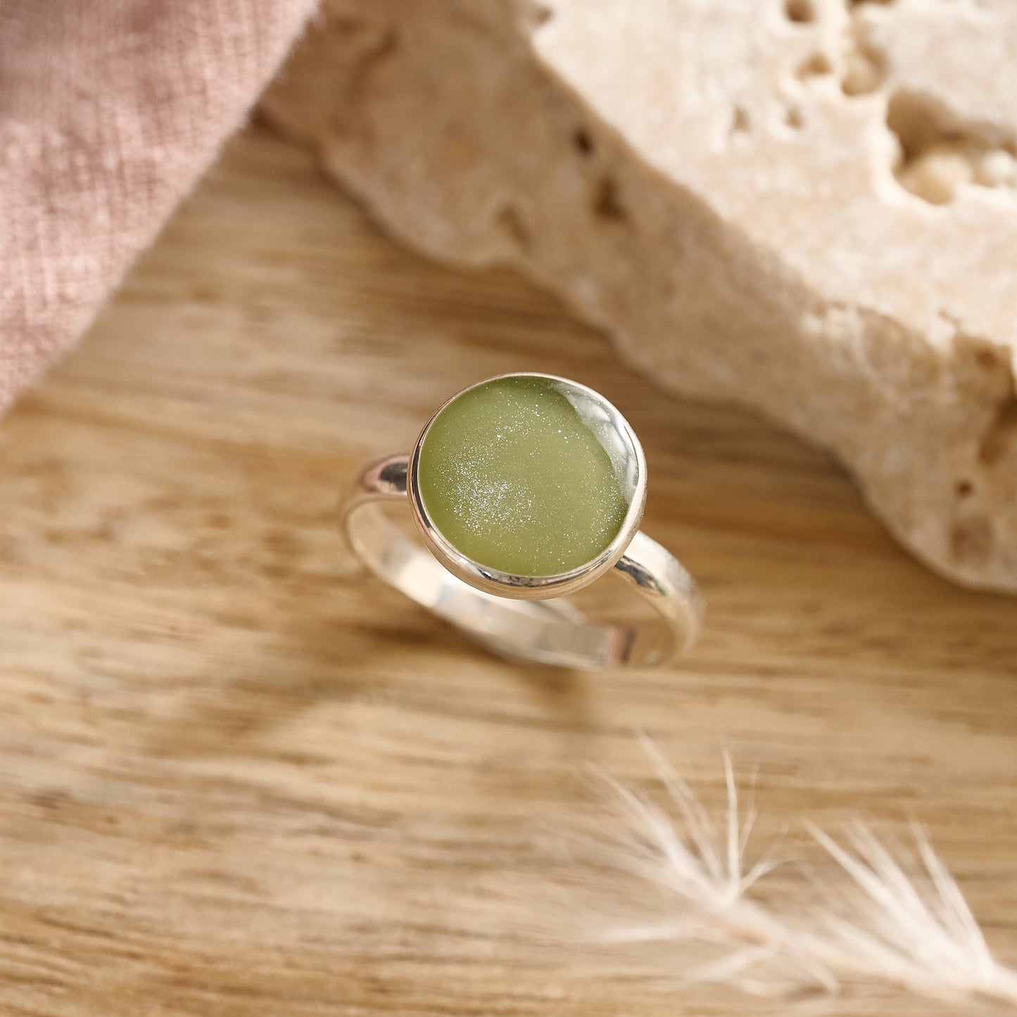 Sage resin cremation ring in sterling silver on wooden table – handmade keepsake jewellery