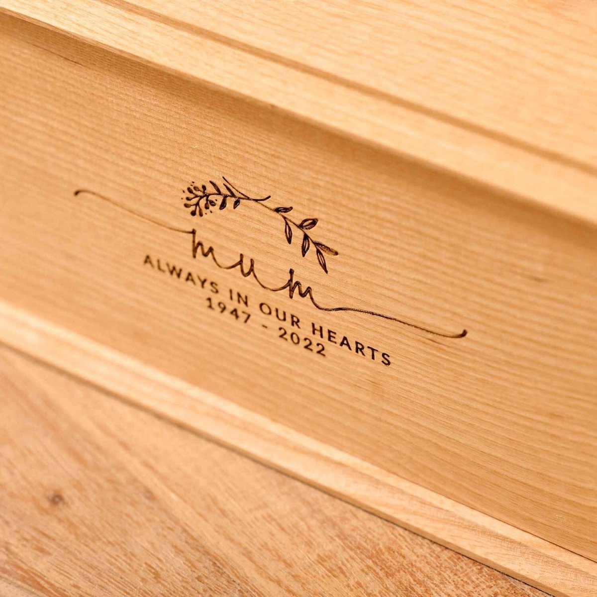 Detailed view of personalised ash wood urn with laurel wreath engraving – custom ashes urn