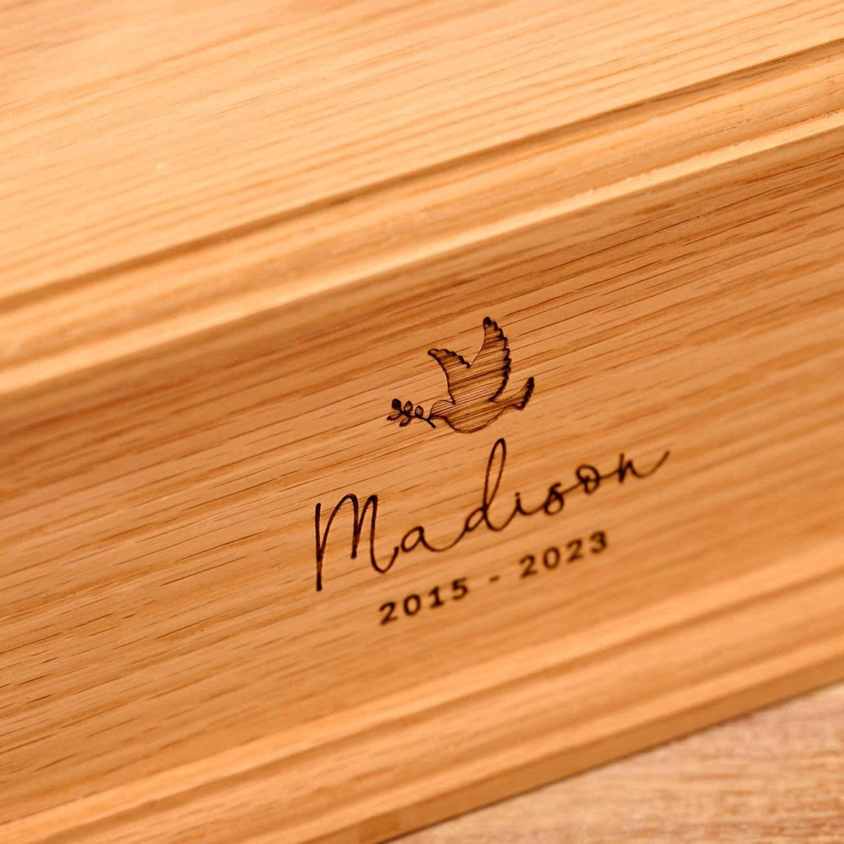 Close-up of engraved oak wood children's cremation urn – detailed view of custom memorial