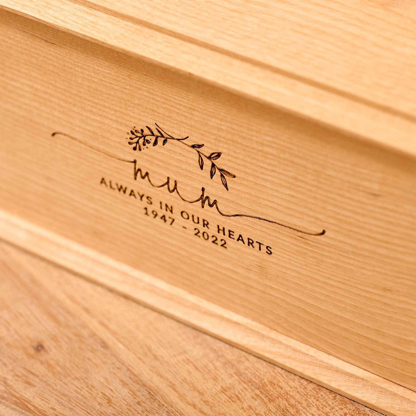Detailed view of personalised ash wood urn with laurel wreath engraving – custom ashes urn