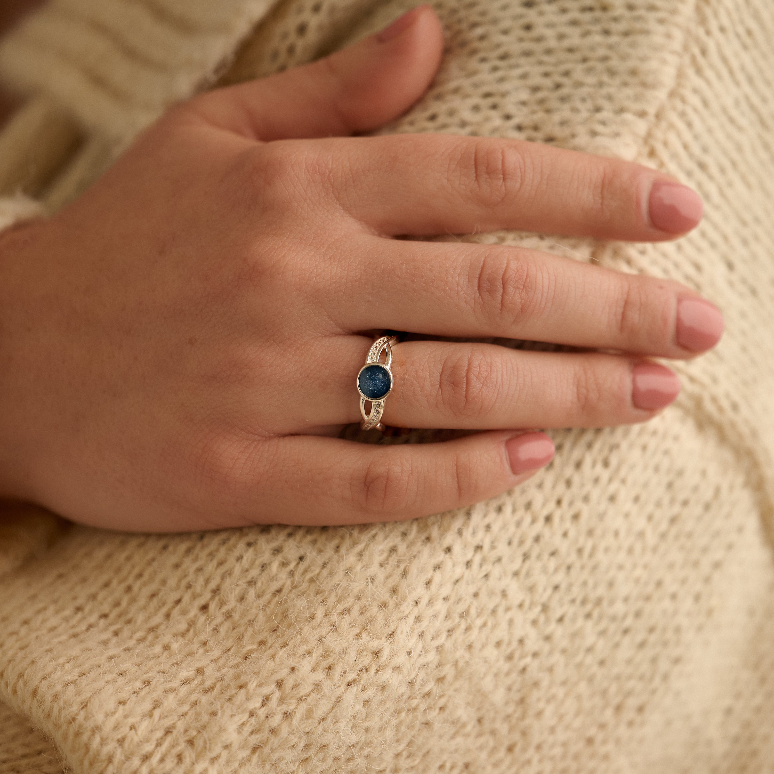 Cremation ashes ring worn by a women who is holding her arm
