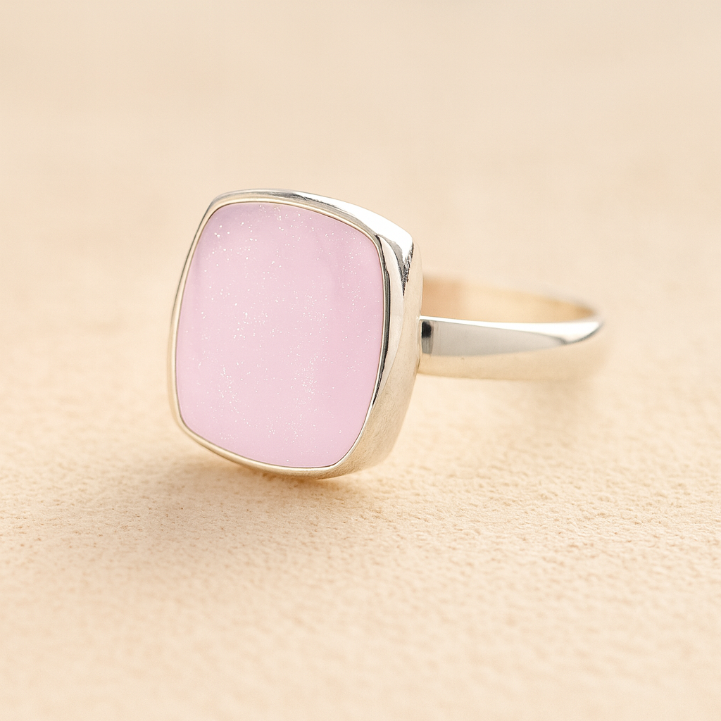 Silver Square Memorial Ashes Cremation Ring with light pink resin, filled with ashes or fur, displayed on a soft beige background – suitable for pet or human memorials.
