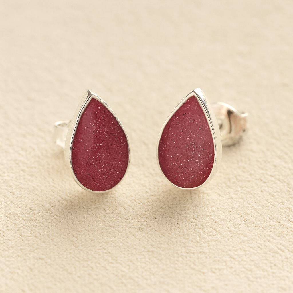 Cremation Ashes Teardrop Earrings with dark pink resin on a beige background