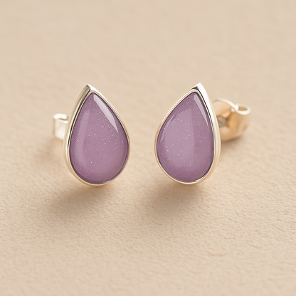 Cremation Ashes Teardrop Earrings with lavender resin on a beige background
