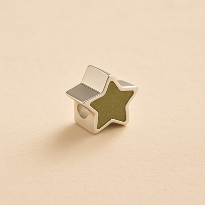 Silver star ashes Charm Bead with a sage resin on a beige background