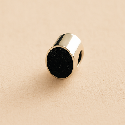 Silver Oval memorial ashes bead with a black resin infill designed to hold cremation ashes and pet fur. Memorial keepsake for pet loss