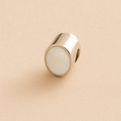 Silver Oval memorial ashes bead with a white resin infill designed to hold cremation ashes and pet fur. Memorial keepsake for pet loss