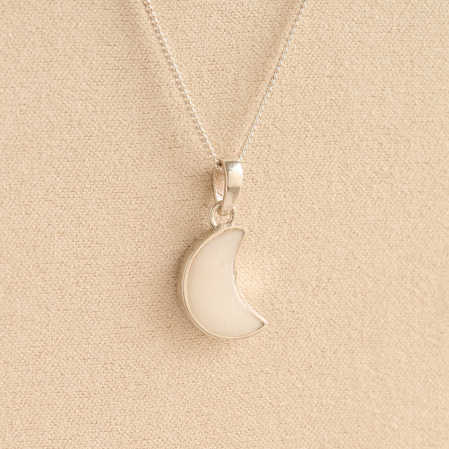 Silver Moon memorial Necklace with white resin, filled with ashes or fur, displayed on a soft beige background – suitable for pet or human memorials.