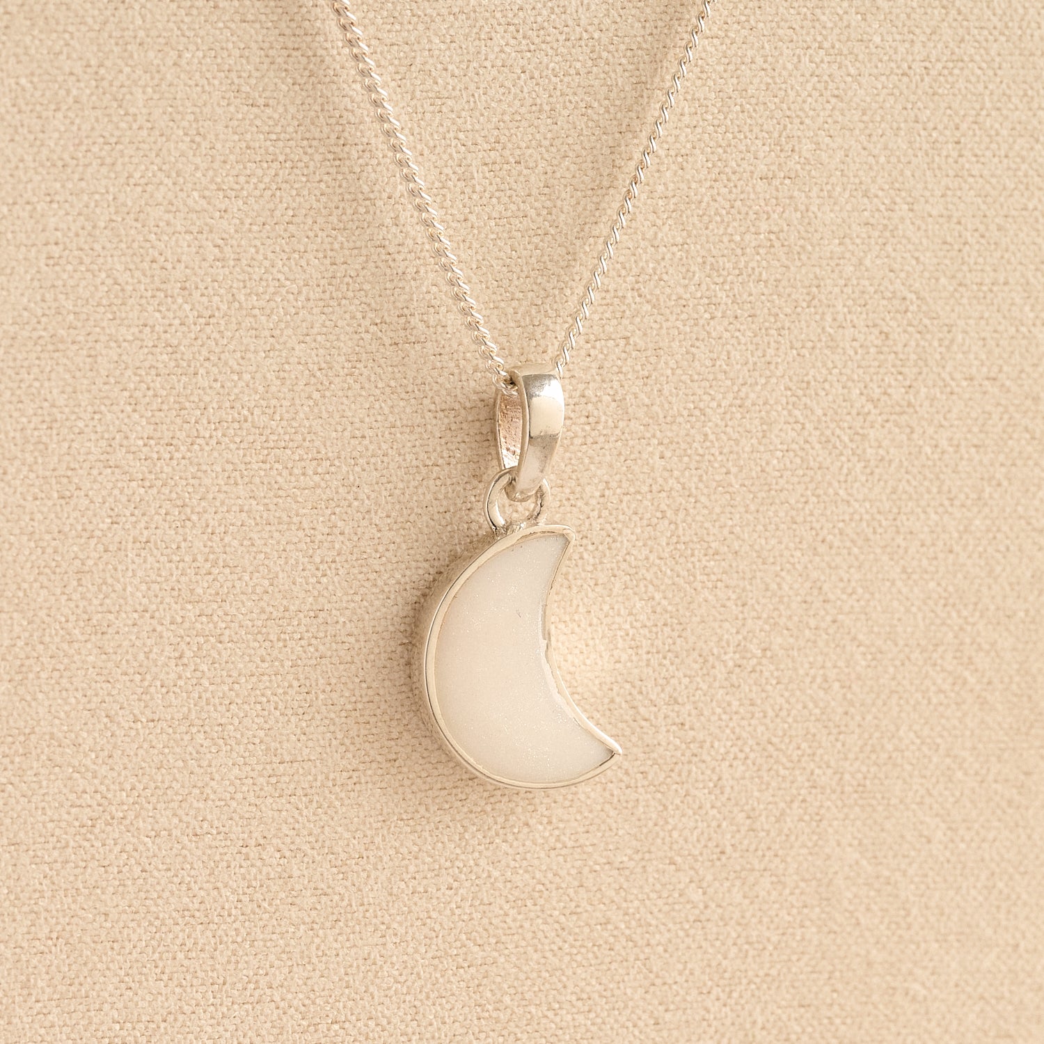 Silver Moon memorial Necklace with white resin, filled with ashes or fur, displayed on a soft beige background – suitable for pet or human memorials.