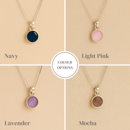 A collection of round Silver Cremation ashes necklace in navy, light pink, lavender and mocha resin filled with ashes or fur, displayed on a soft beige background – suitable for pet or human memorials.
