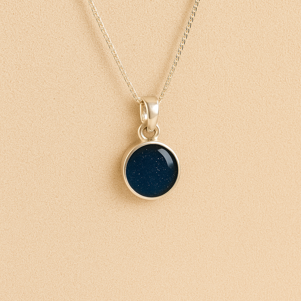 A round Silver Cremation ashes necklace navy resin filled with ashes or fur, displayed on a soft beige background – suitable for pet or human memorials.