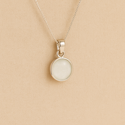 Silver Cremation ashes necklace with a round pendant and white resin filled with ashes or fur, displayed on a soft beige background – suitable for pet or human memorials.
