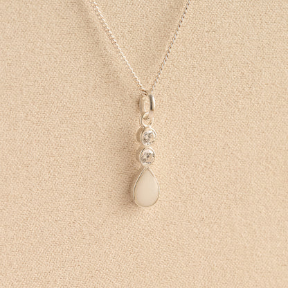 Silver Cremation ashes necklace with a teardrop pendant and white resin filled with ashes or fur, displayed on a soft beige background – suitable for pet or human memorials.