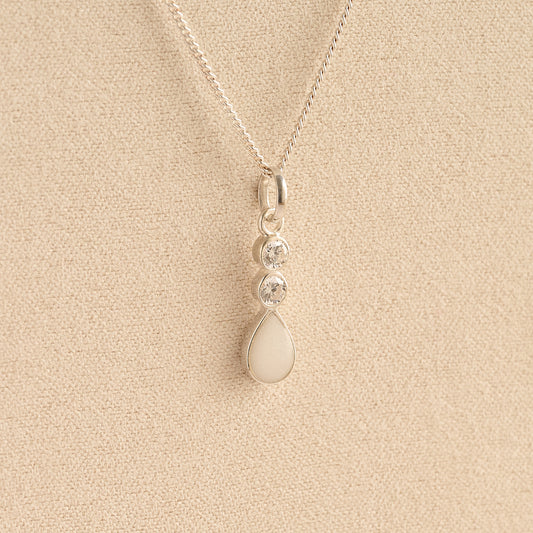 Silver Cremation ashes necklace with a teardrop pendant and white resin filled with ashes or fur, displayed on a soft beige background – suitable for pet or human memorials.