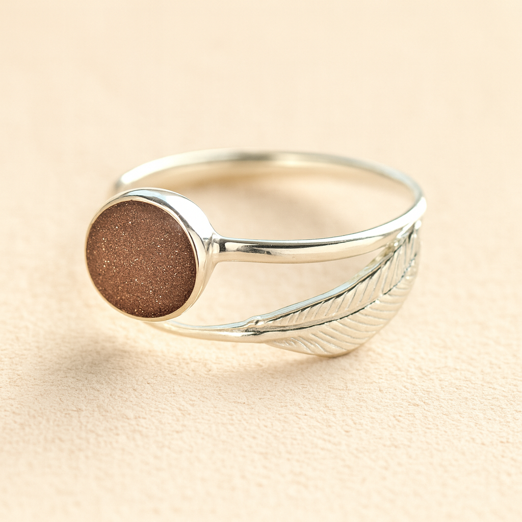 Adjustable Silver feather ashes ring with a mocha resin on a beige background