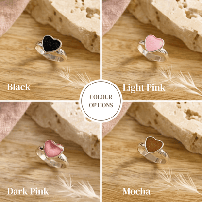 Heart-shaped ashes rings in black, light pink, dark pink, and mocha colors on a wooden background.
