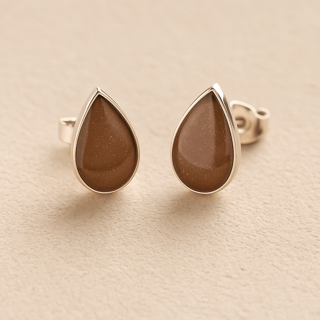 Silver Cremation Ashes Teardrop Earrings with mocha brown resin on a beige background