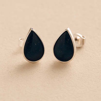Silver teardrop memorial Ashes Earrings with navy resin on a beige background