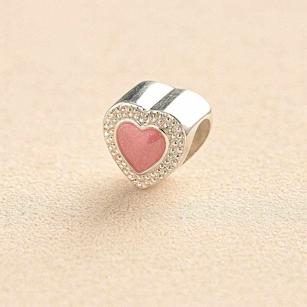 Silver Heart-shaped cremation charm with pink resin center and crystal border on beige background