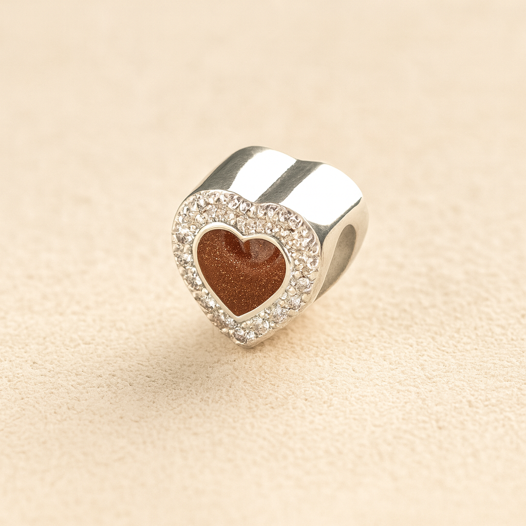 Silver heart-shaped Pandora cremation charm with a mocha resin center on a beige background