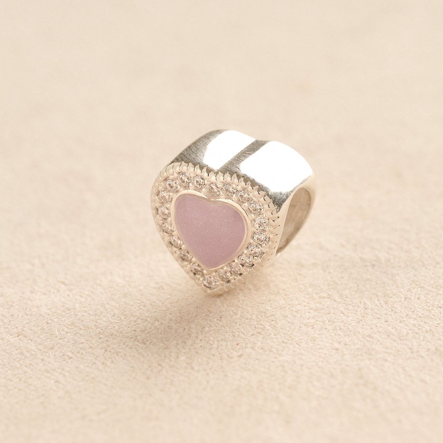 Silver heart ashes charm with crystals on a beige background