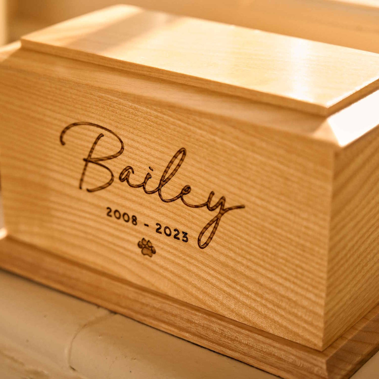 Personalised wooden pet cremation urn with engraved name and paw print