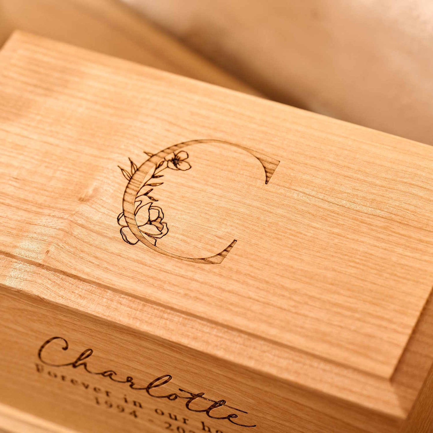Detailed view of custom floral engraving on wooden urn.