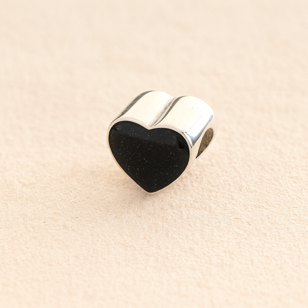Silver Heart Cremation ashes charm with black resin filled with ashes or fur, displayed on a soft beige background – suitable for pet or human memorials.