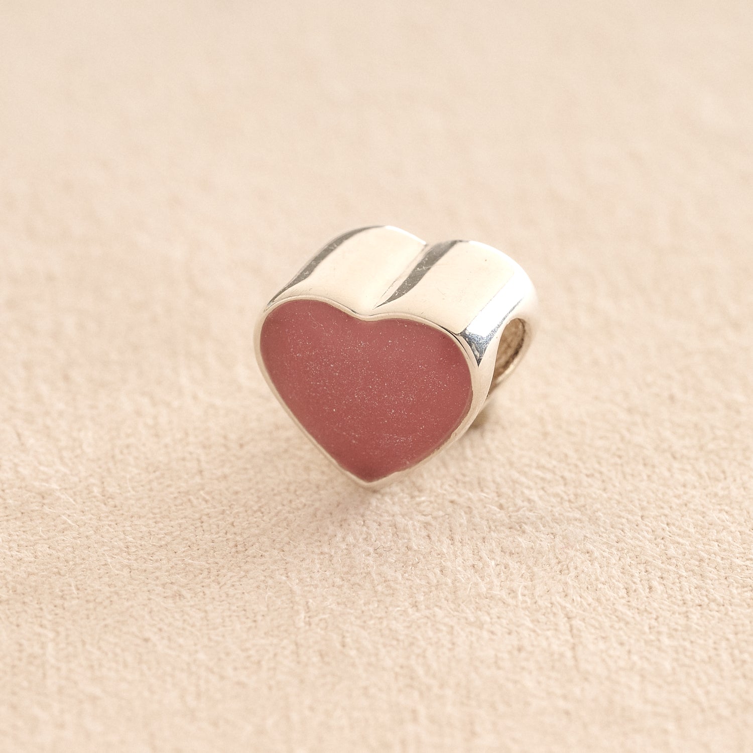 Silver Heart Cremation ashes charm with dark pink resin filled with ashes or fur, displayed on a soft beige background – suitable for pet or human memorials.