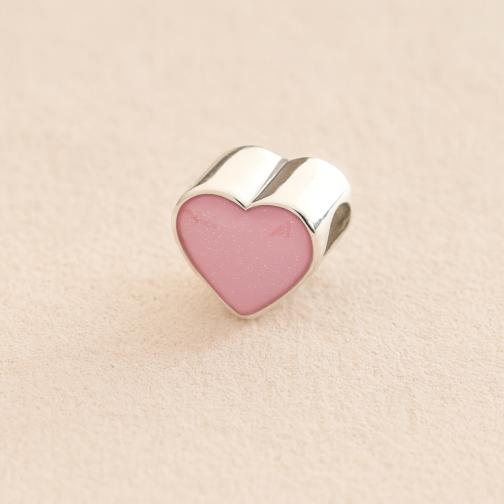 Silver Heart Cremation ashes charm with light pink resin filled with ashes or fur, displayed on a soft beige background – suitable for pet or human memorials.