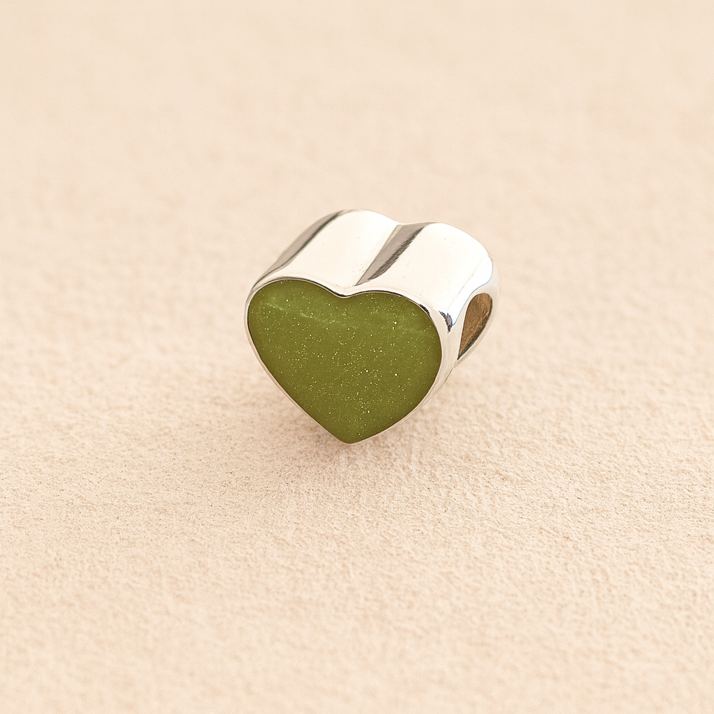 Silver Heart Cremation ashes charm with sage resin filled with ashes or fur, displayed on a soft beige background – suitable for pet or human memorials.