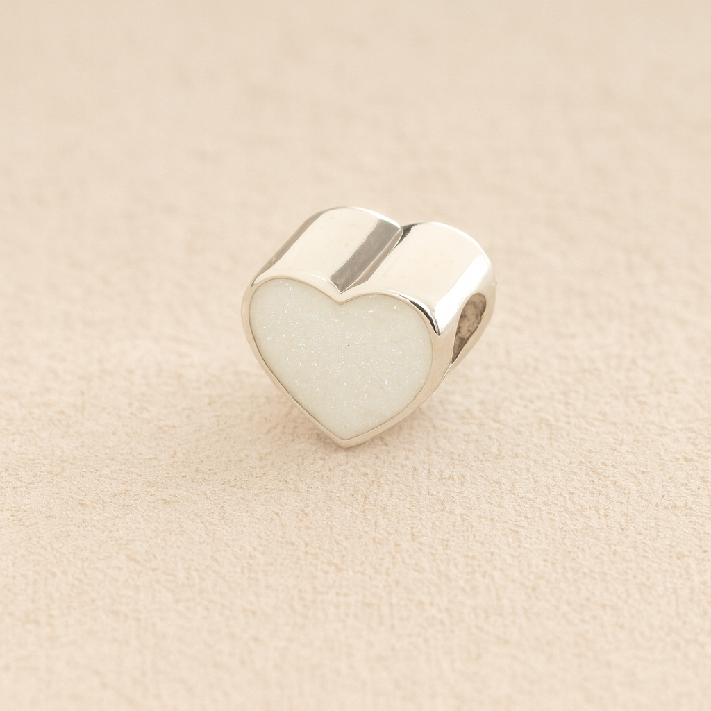 Silver Heart Cremation ashes charm with white resin filled with ashes or fur, displayed on a soft beige background – suitable for pet or human memorials.