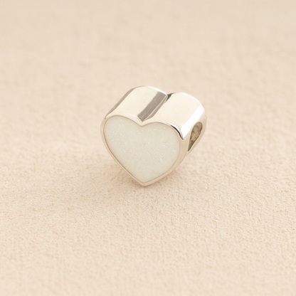 Silver Heart Cremation ashes charm with white resin filled with ashes or fur, displayed on a soft beige background – suitable for pet or human memorials.