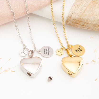 Two heart-shaped pet memorial pendants on necklaces with engraved text on a light background