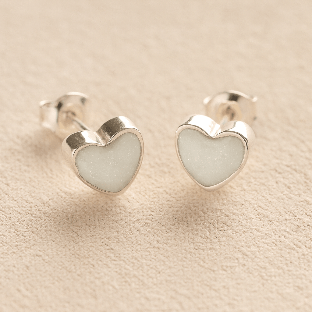 Silver Heart ashes earrings with white resin with pet ashes or fur a beige fabric background