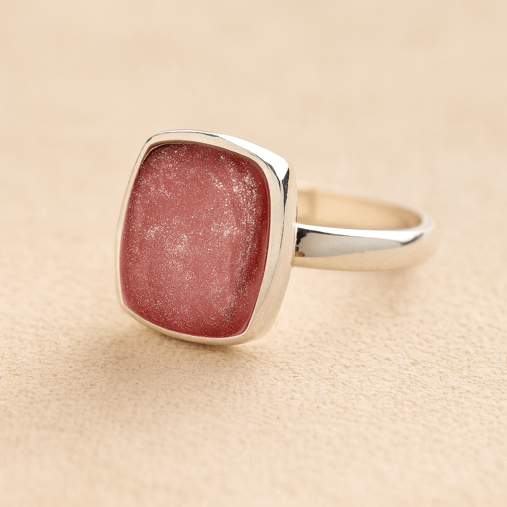 Silver Square Memorial Ashes Cremation Ring with dark pink resin, filled with ashes or fur, displayed on a soft beige background – suitable for pet or human memorials.