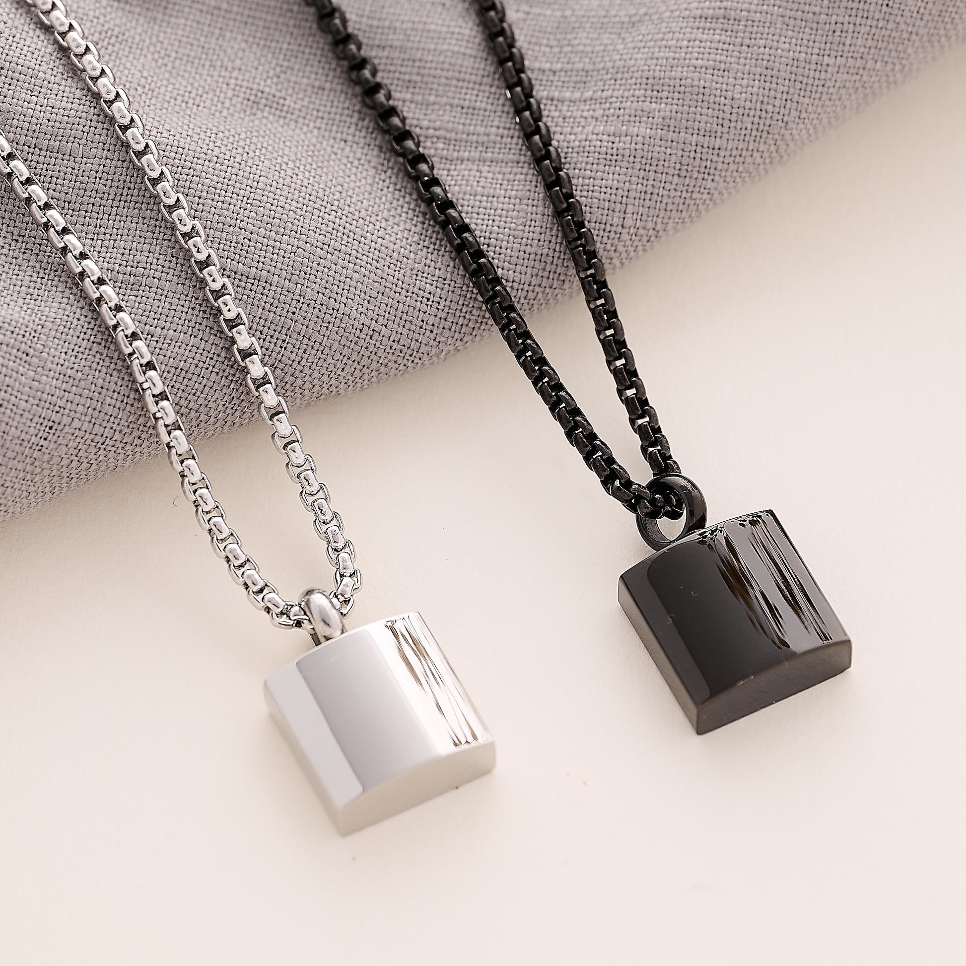 Silver and black Men’s Square memorial Pendant on a beige background 