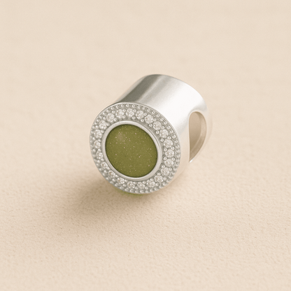 Silver Circle CZ Ashes Charm with Sage resin on a beige background