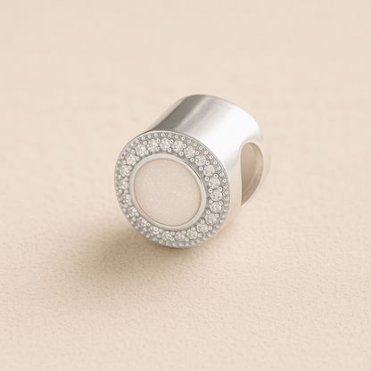 Silver Circle CZ Ashes Charm with White resin on a beige background