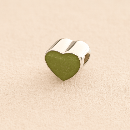 Silver Heart Cremation ashes charm with sage resin filled with ashes or fur, displayed on a soft beige background – suitable for pet or human memorials.