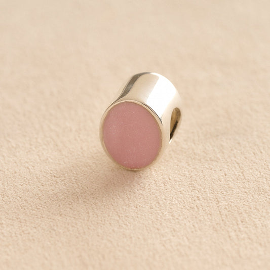 Silver Oval memorial ashes bead with a light pink resin infill designed to hold cremation ashes and pet fur. Memorial keepsake for pet loss