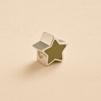 Silver star ashes Charm Bead with a sage resin on a beige background