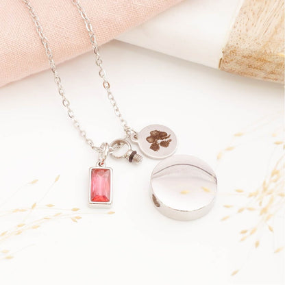 Paw print necklace with self fill urn pendant and birthstone charm on a light background. Memorial Jewellery for him